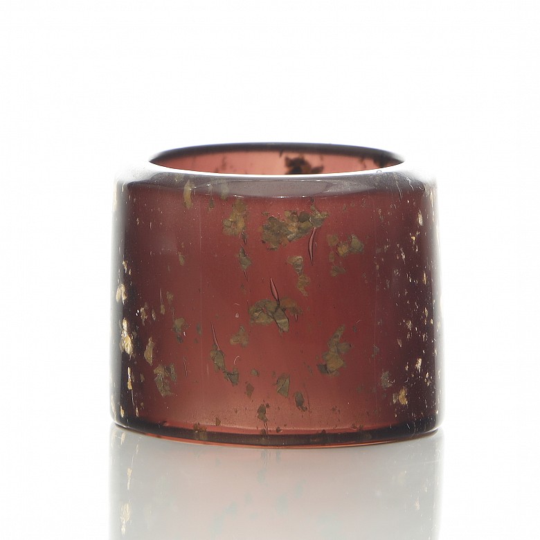 Archer's ring of pink glass and gold leaf shavings, 20th century