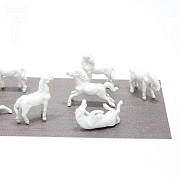 Seven miniature white porcelain horses.