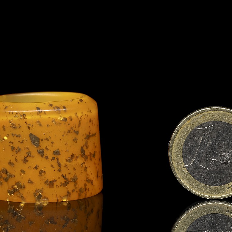 Orange glass archer's ring with gold leaf shavings, 20th century