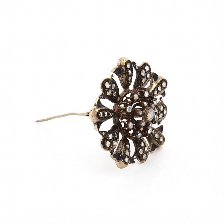 Antiguo broche de metal con diamantes.