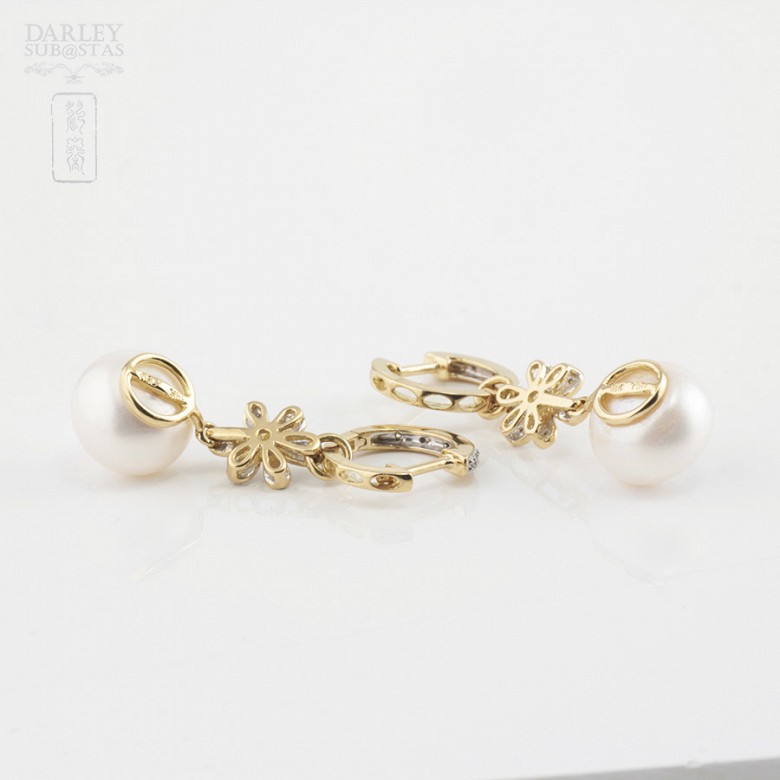 Pearl earrings in 18k yellow gold and diamonds.