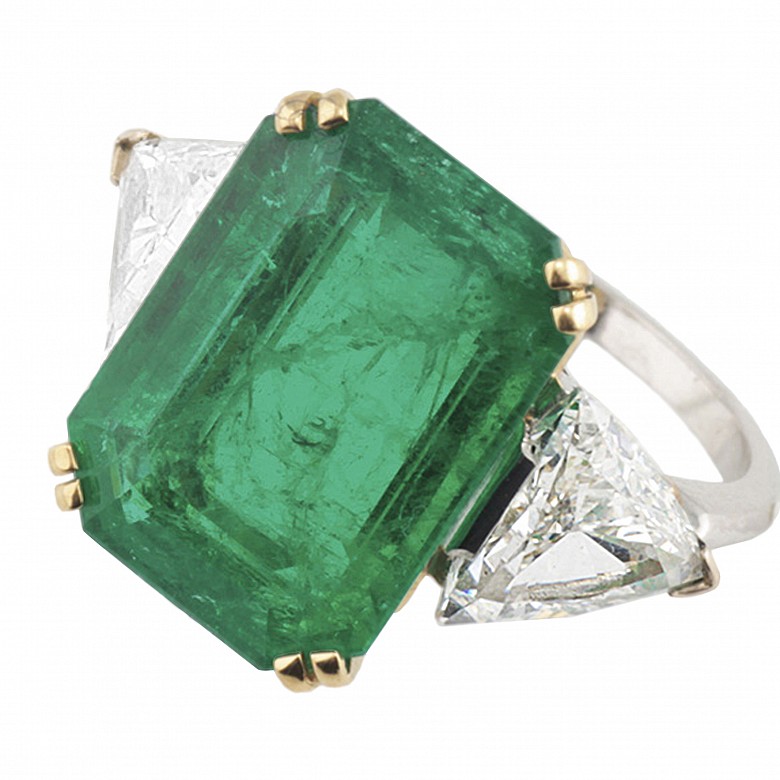 Ring with a large Colombian emerald of 11.19ct and triangle cut diamonds on both sides.