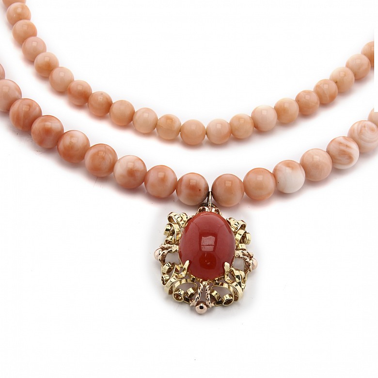 Long coral bead necklace with pendant.