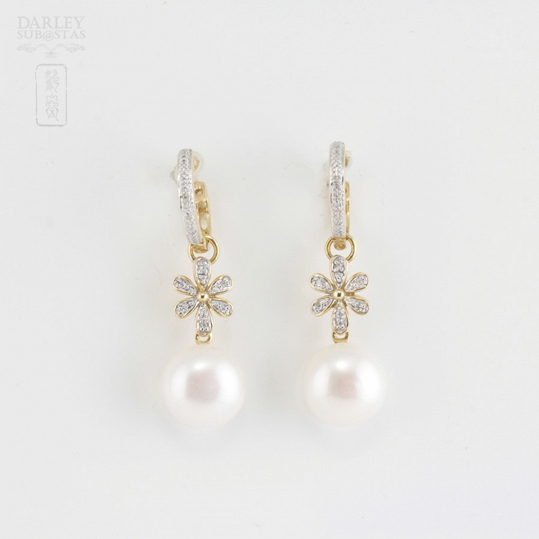 Pearl earrings in 18k yellow gold and diamonds.