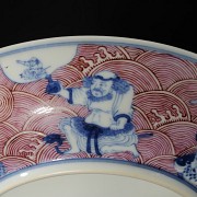 Porcelain plate in red, blue and white ‘The Eight Immortals’, with Qianlong trademark