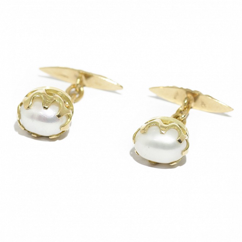 Cufflinks with white oval shaped pearls.