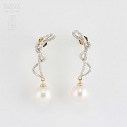 Long earrings with pearls in 18k yellow gold and diamonds.