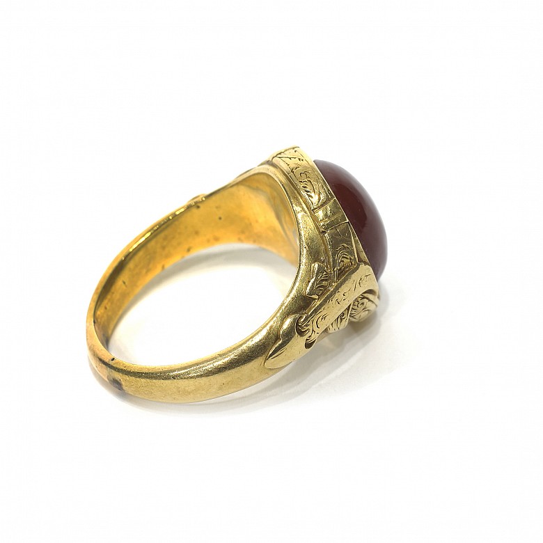 Anillo en oro con un ágata roja central.