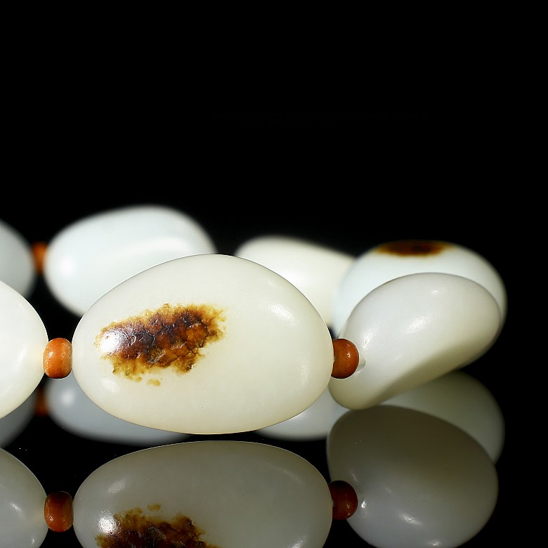 Bracelet of nine carved jade beads, 20th century