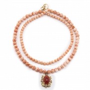 Long coral bead necklace with pendant.