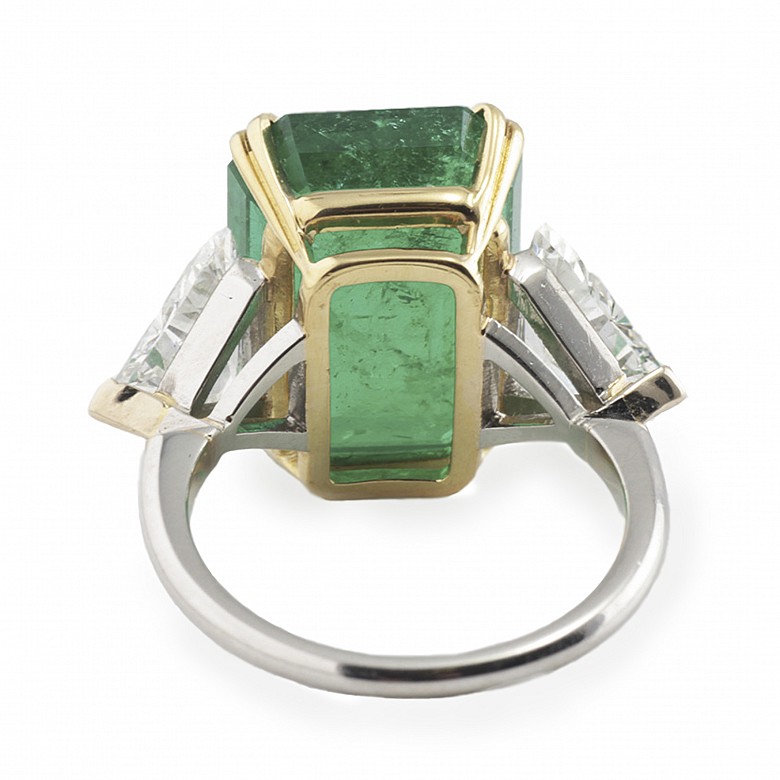 Ring with a large Colombian emerald of 11.19ct and triangle cut diamonds on both sides.