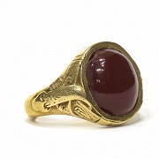 Anillo en oro con un ágata roja central.