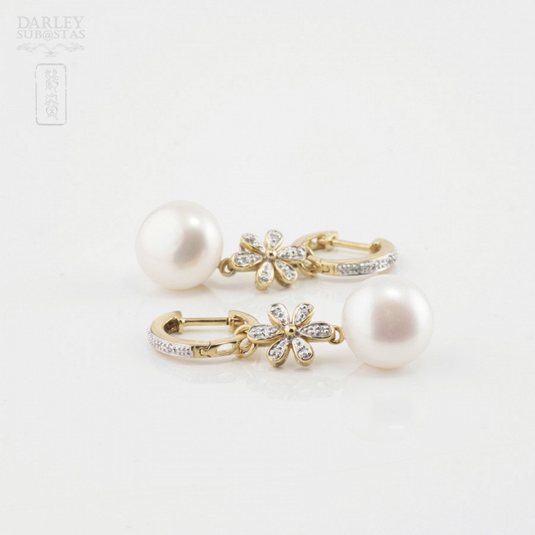 Pearl earrings in 18k yellow gold and diamonds.