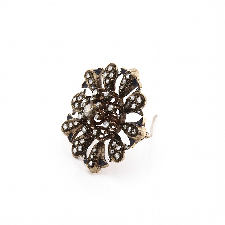 Antiguo broche de metal con diamantes.