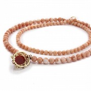 Long coral bead necklace with pendant.