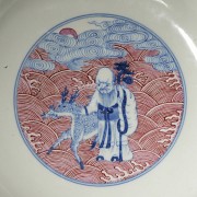 Porcelain plate in red, blue and white ‘The Eight Immortals’, with Qianlong trademark