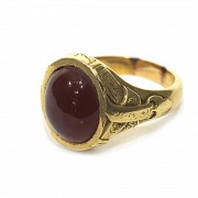 Anillo en oro con un ágata roja central.