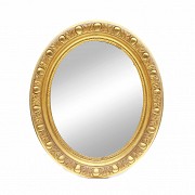 Oval mirror with golden wood frame.