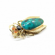 Beetle-shaped brooch in 18k yellow gold, natural turquoise and gemstones.