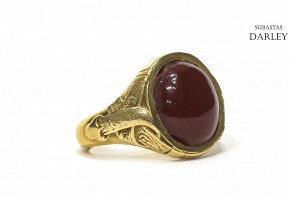 Anillo en oro con un ágata roja central.